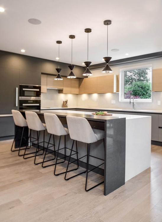 جزیره آشپزخانه نــوآرتا با صفحه سفید واترفال و پنل بار تیره در فضای مدرن